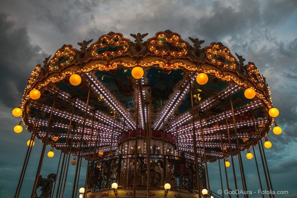 PARIS, FRANCE - AUGUST 30, 2015: Old French carousel in a holiday park at night summer time.